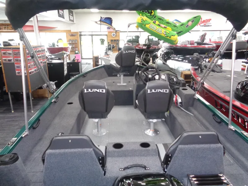 Slide: The Image of 2025 Lund 1650 Rebel XL SS boat interior with seating and steering console in showroom. - 16