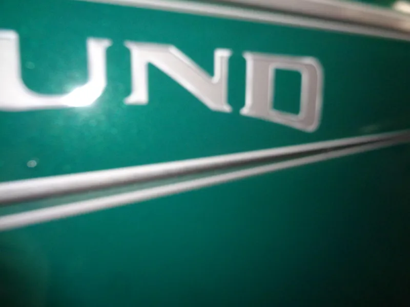 Slide: The Image of Close-up of 2025 Lund 1650 Rebel XL SS boat logo on green surface. - 4