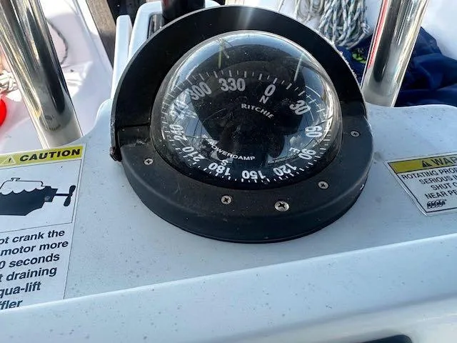 Slide: The Image of Compass on 2017 Catalina 315 sailboat dashboard with caution labels. - 12