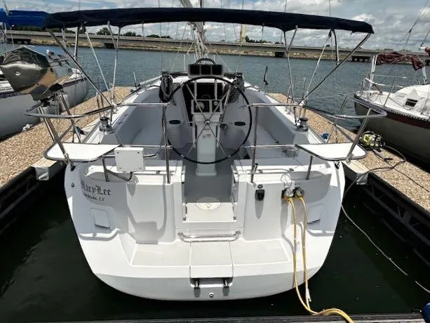 Slide: The Image of 2017 Catalina 315 sailboat docked, featuring spacious cockpit and dual steering wheels. - 4