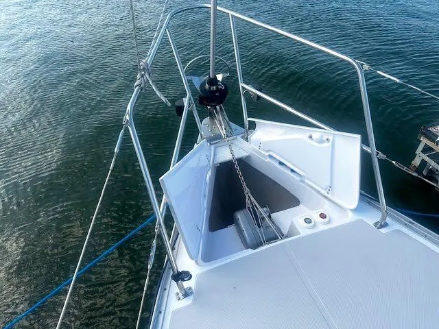 Slide: The Image of 2017 Catalina 315 sailboat bow with anchor locker, stainless steel railings, and calm water background. - 5