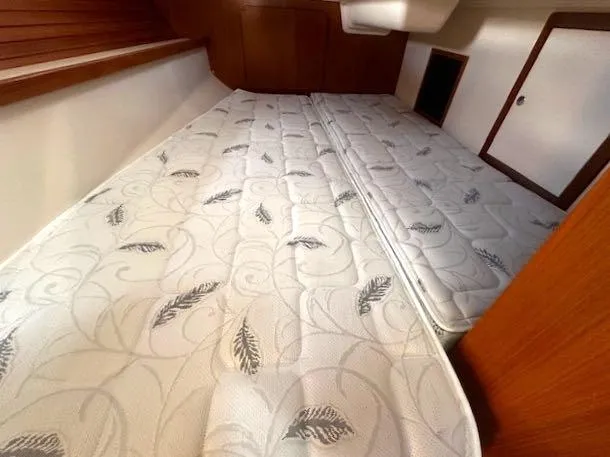 Slide: The Image of 2017 Catalina 315 cabin interior with patterned mattress and wooden accents. - 9
