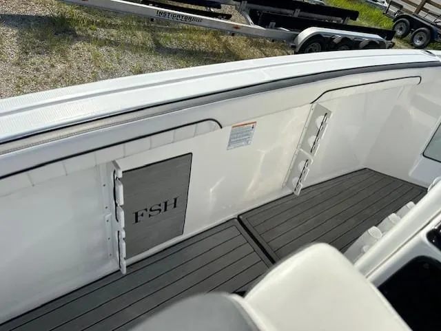Slide: The Image of 2022 Yamaha Boats 255 FSH Sport E interior with sleek deck and storage compartments. - 10