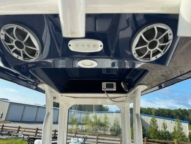 Slide: The Image of 2022 Yamaha Boats 255 FSH Sport E, featuring speakers and control panel on the overhead console. - 13