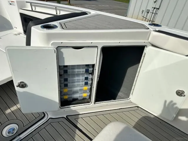 Slide: The Image of 2022 Yamaha Boats 255 FSH Sport E storage compartments with tackle boxes on deck. - 15