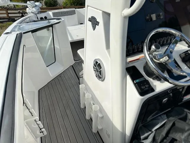 Slide: The Image of 2022 Yamaha Boats 255 FSH Sport E interior with steering wheel and deck view. - 17