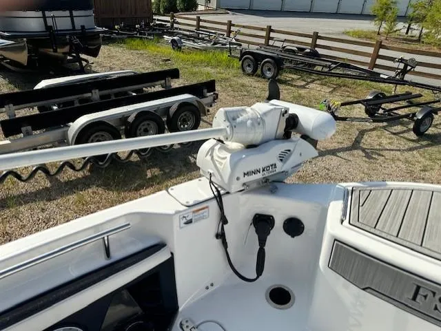 Slide: The Image of Yamaha Boats 2022 255 FSH Sport E with Minn Kota trolling motor, parked near trailers. - 18