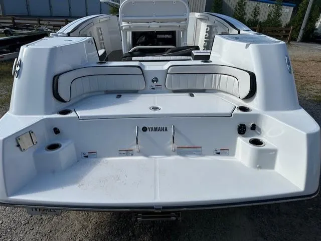 Slide: The Image of 2022 Yamaha Boats 255 FSH Sport E, rear view, white seating, outdoor setting. - 4