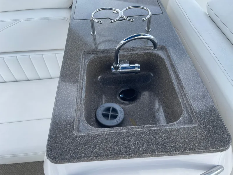 Slide: The Image of 2005 Regal 3350 Sport Cruiser sink with faucet and cup holders on deck. - 15