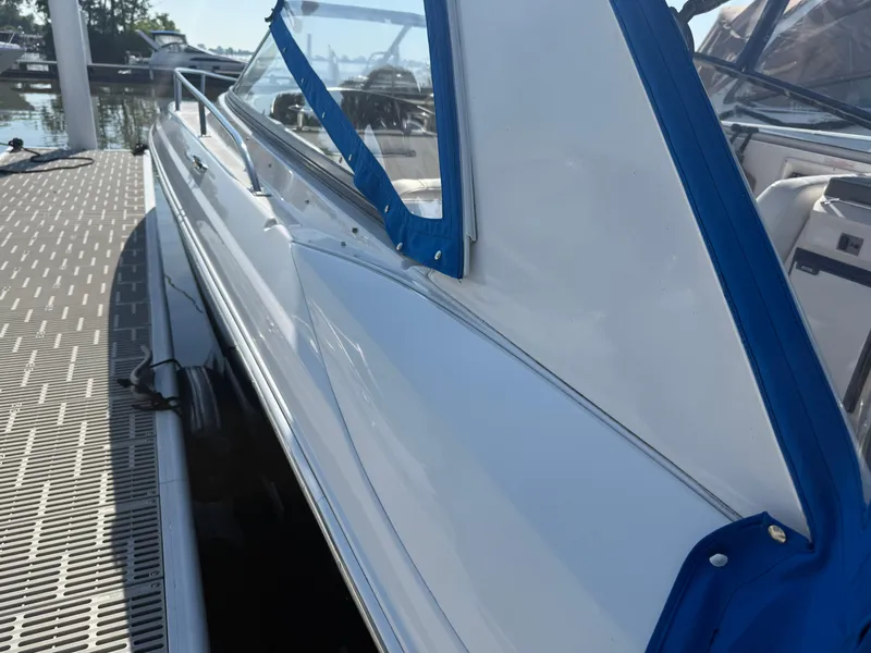 Slide: The Image of 2005 Regal 3350 Sport Cruiser docked, featuring sleek white exterior and blue trim. - 18