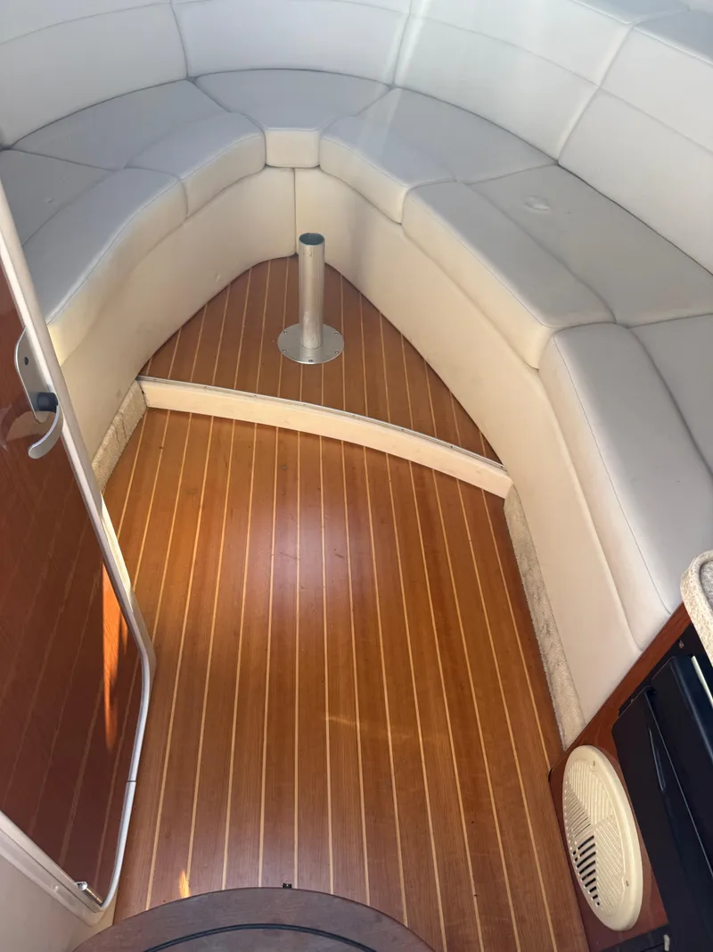 Slide: The Image of 2005 Regal 3350 Sport Cruiser interior with white seating and wooden flooring. - 5