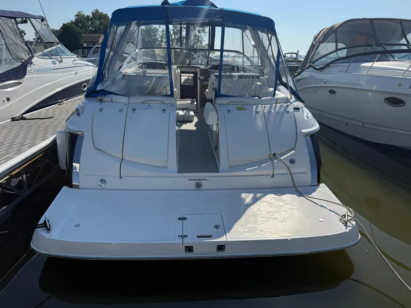 Slide: The Image of 2005 Regal 3350 Sport Cruiser docked, rear view with blue canopy. - 8