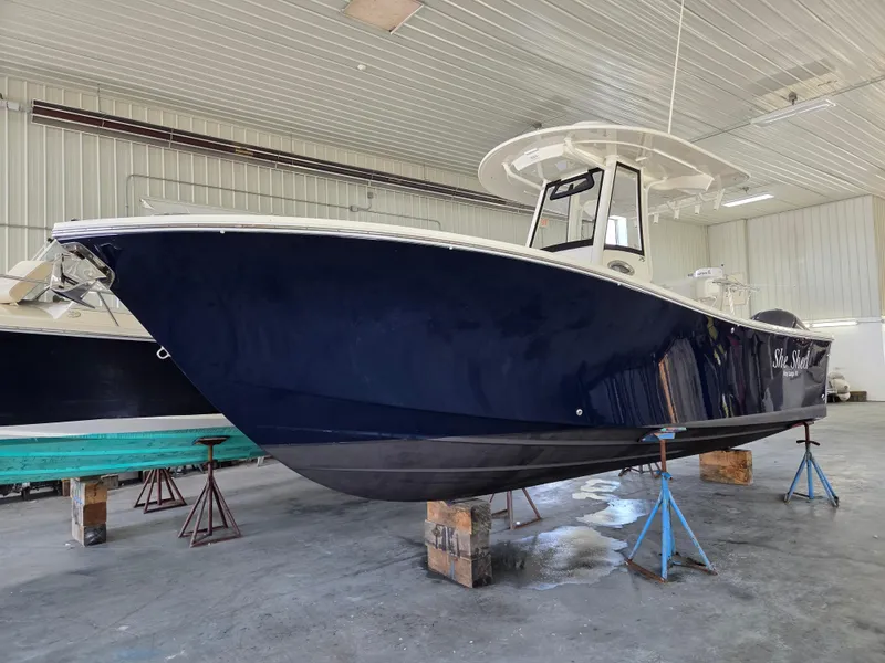 Slide: The Image of 2020 Regulator 25 boat in indoor storage, elevated on stands. - 0