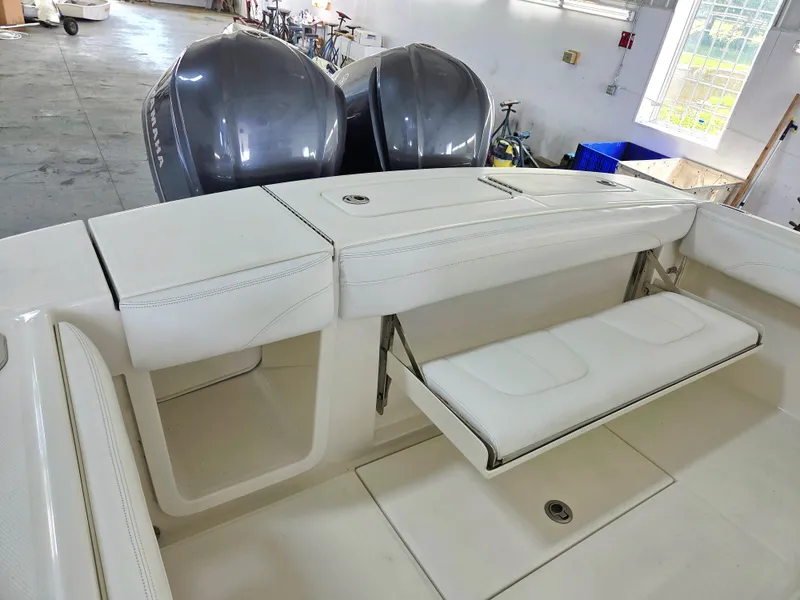 Slide: The Image of 2020 Regulator 25 boat interior with foldable seating and dual Yamaha engines in a garage setting. - 10