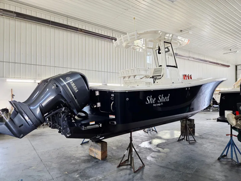 Slide: The Image of 2020 Regulator 25 boat with Yamaha engine in a garage setting. - 2