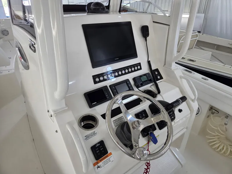 Slide: The Image of 2020 Regulator 25 boat dashboard with steering wheel and electronic controls. - 5