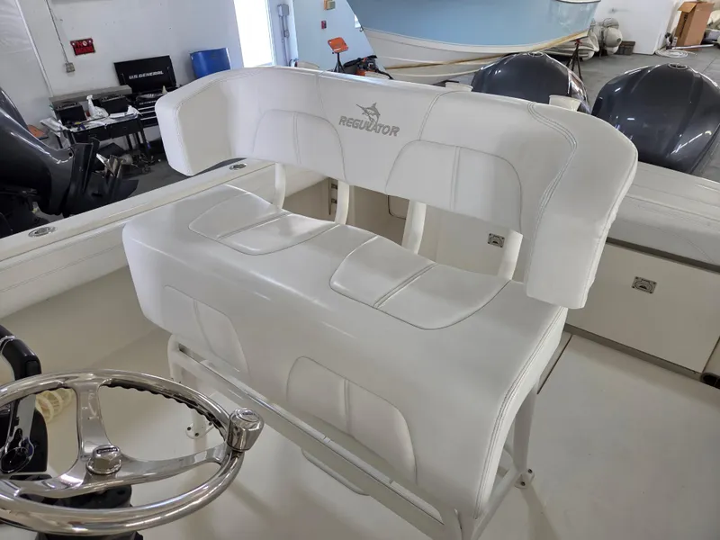 Slide: The Image of 2020 Regulator 25 boat interior with white seating and steering wheel. - 8