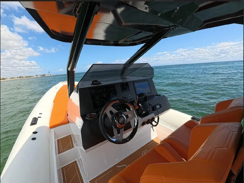 Slide: The Image of 2026 Novielli Veloche 349 boat interior with orange seats, steering wheel, and ocean view. - 11