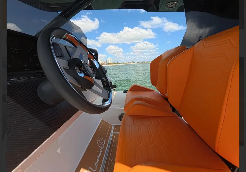Slide: The Image of 2026 Novielli Veloche 349 boat interior with orange seats and steering wheel, ocean view. - 12