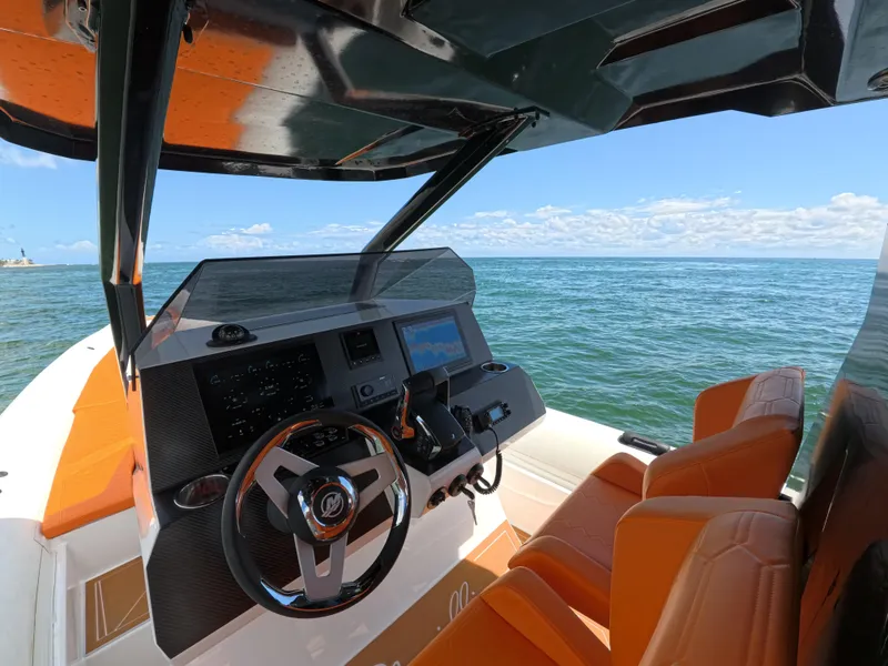 Slide: The Image of Cockpit of 2026 Novielli Veloche 349 boat with orange seats, steering wheel, and ocean view. - 15
