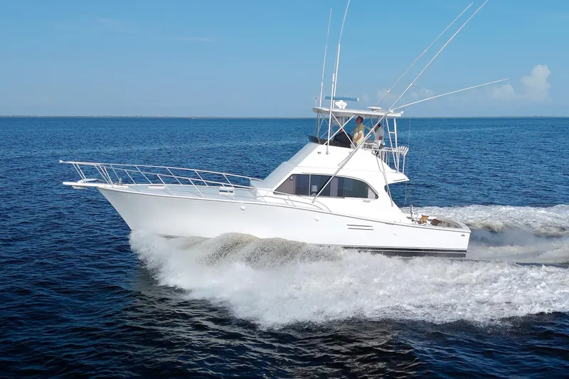 The Image of 1990 Post 44 Sport Fisherman cruising on open water under clear blue skies. - 0