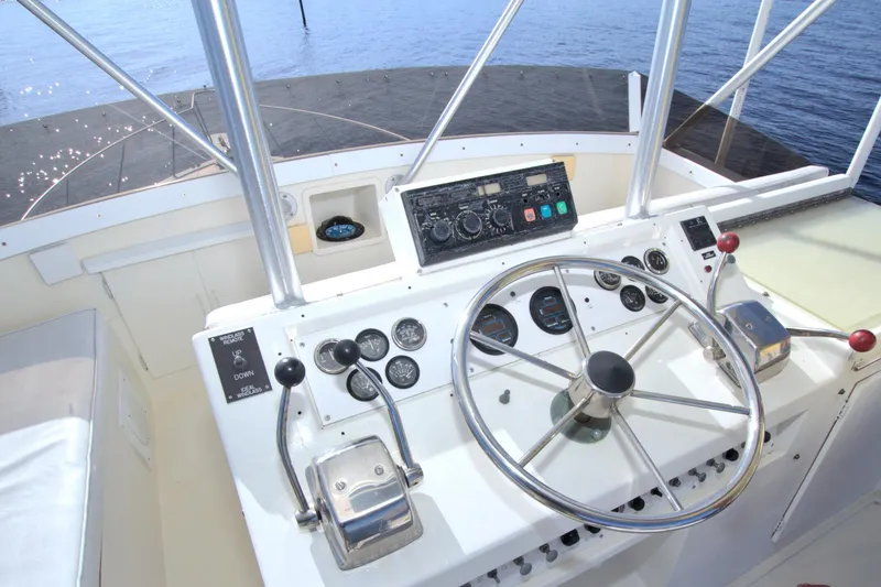 Slide: The Image of 1990 Post 44 Sport Fisherman helm with steering wheel and control panel, overlooking water. - 14