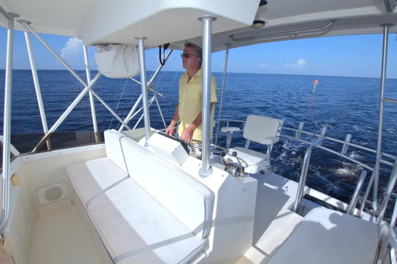 Slide: The Image of Man steering 1990 Post 44 Sport Fisherman boat on open sea. - 17