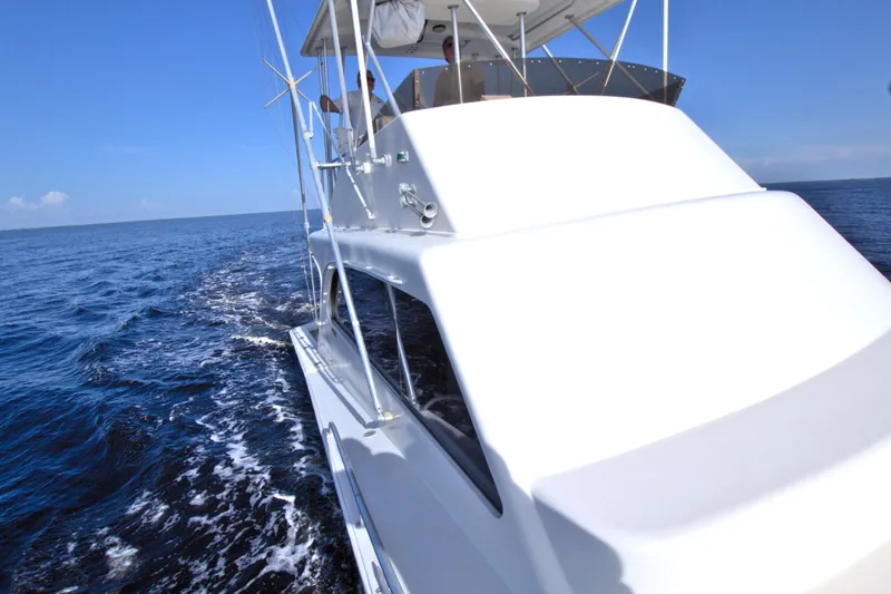 Slide: The Image of 1990 Post 44 Sport Fisherman yacht cruising on open sea under clear blue sky. - 25