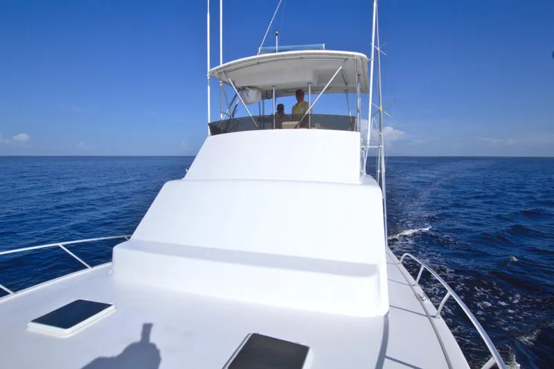 Slide: The Image of 1990 Post 44 Sport Fisherman boat cruising on open sea under clear blue sky. - 29