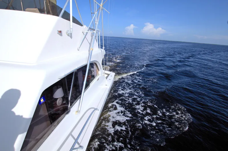Slide: The Image of 1990 Post 44 Sport Fisherman yacht cruising on open sea under clear blue sky. - 30
