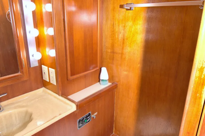 Slide: The Image of 1990 Post 44 Sport Fisherman bathroom with wooden cabinetry and vanity lighting. - 45