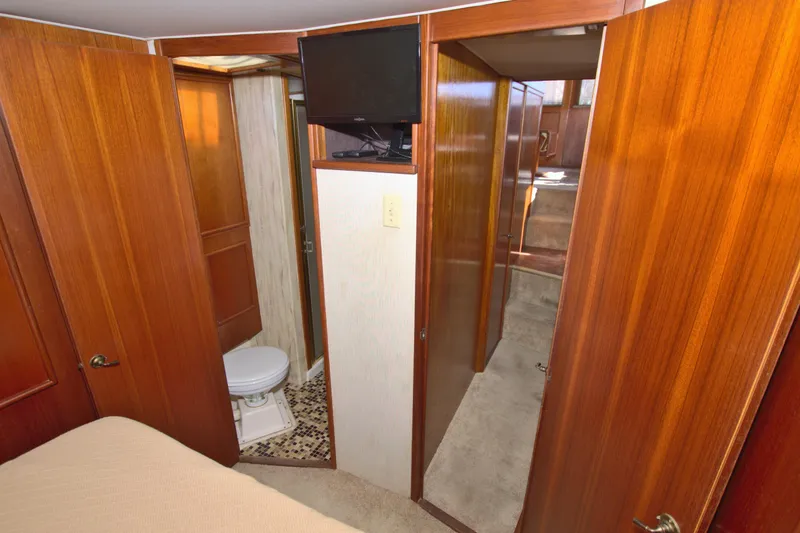 Slide: The Image of 1990 Post 44 Sport Fisherman interior with wood paneling, bathroom, and TV. - 51