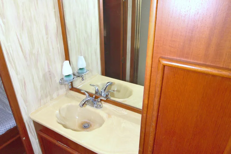 Slide: The Image of Bathroom sink area in a 1990 Post 44 Sport Fisherman yacht, featuring wood cabinetry. - 55