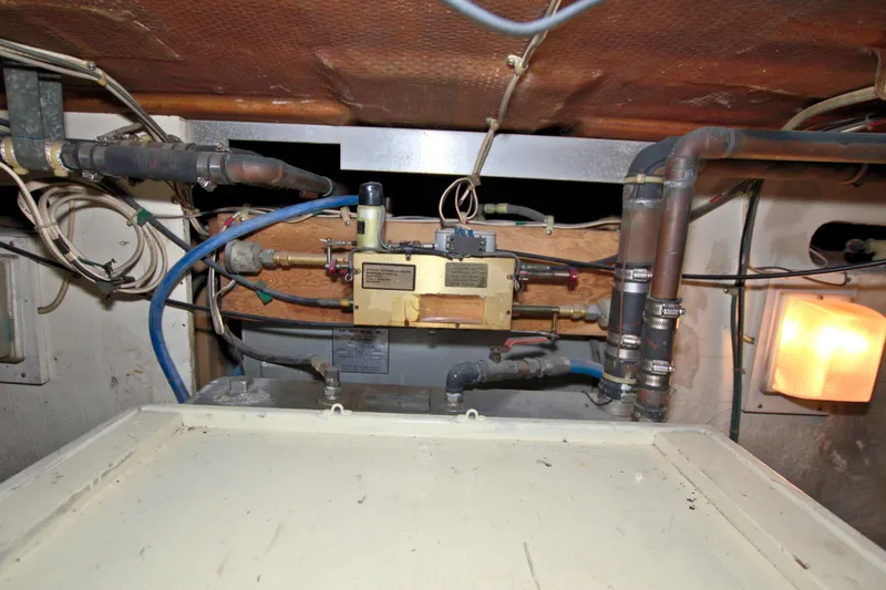 Slide: The Image of Engine room of a 1990 Post 44 Sport Fisherman boat, showing pipes and wiring. - 77