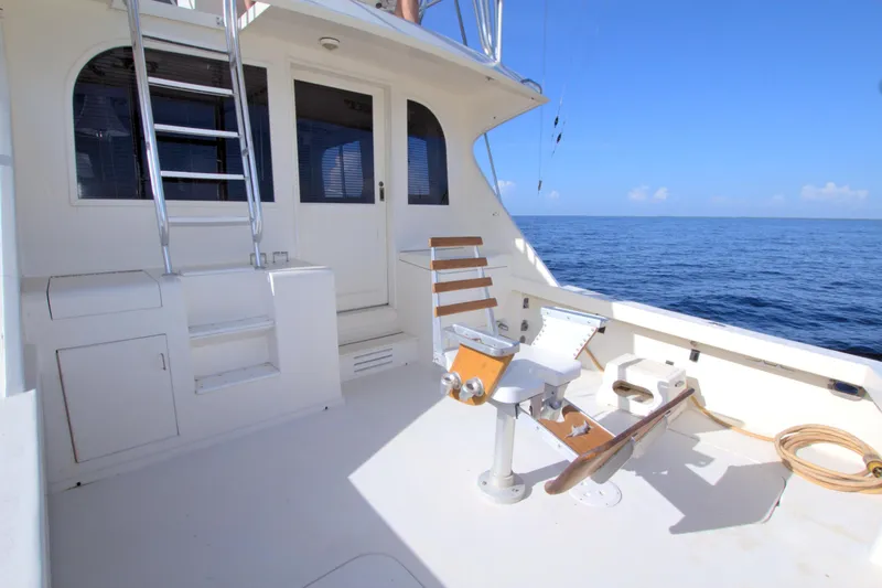 Slide: The Image of 1990 Post 44 Sport Fisherman boat deck with fishing chair, ocean view, and clear blue sky. - 21