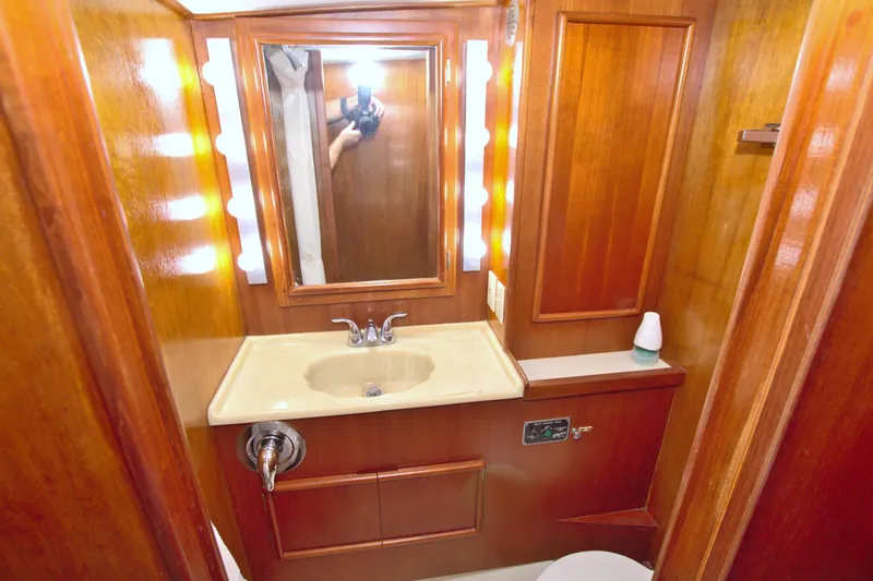 Slide: The Image of 1990 Post 44 Sport Fisherman bathroom with wooden cabinetry and illuminated mirror. - 44