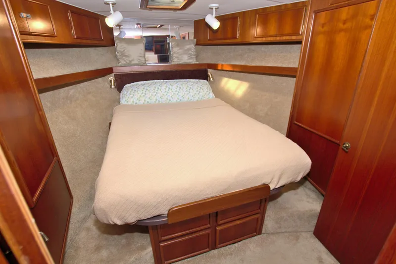 Slide: The Image of 1990 Post 44 Sport Fisherman cabin with cozy bed and wooden cabinetry. - 46