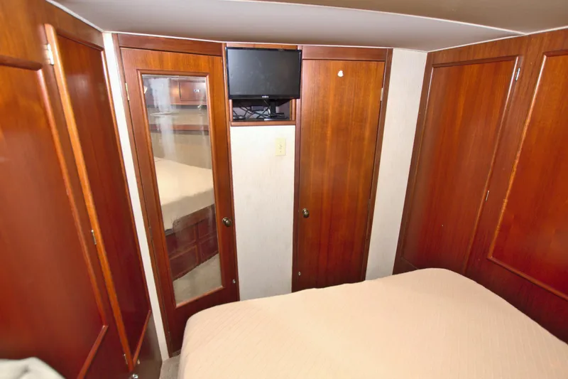 Slide: The Image of 1990 Post 44 Sport Fisherman cabin with wood paneling and mounted TV. - 50