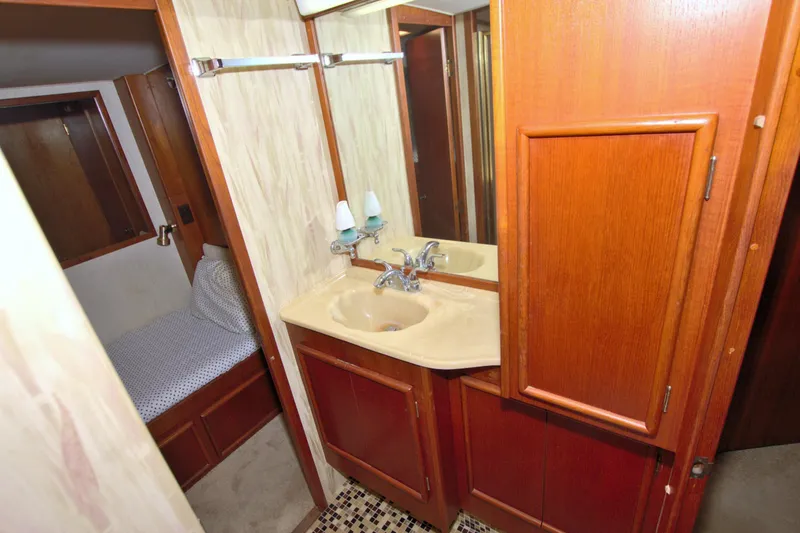 Slide: The Image of 1990 Post 44 Sport Fisherman bathroom with wooden cabinets and beige sink. - 56