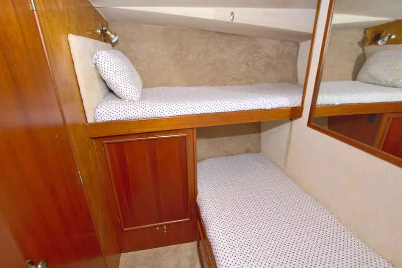 Slide: The Image of 1990 Post 44 Sport Fisherman cabin with wooden bunk beds and polka dot bedding. - 58