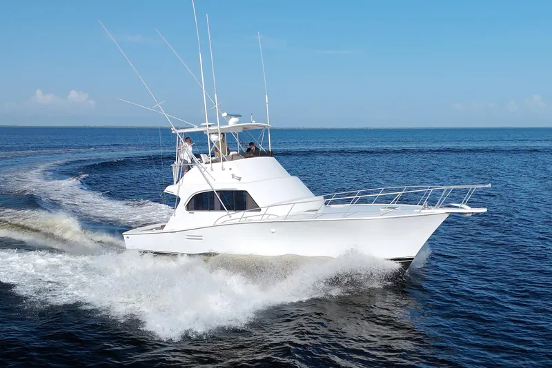 Slide: The Image of 1990 Post 44 Sport Fisherman cruising on open water under clear blue skies. - 6