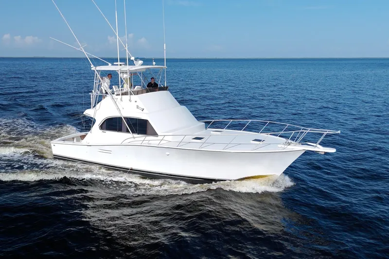 Slide: The Image of 1990 Post 44 Sport Fisherman yacht cruising on open water under clear blue skies. - 80