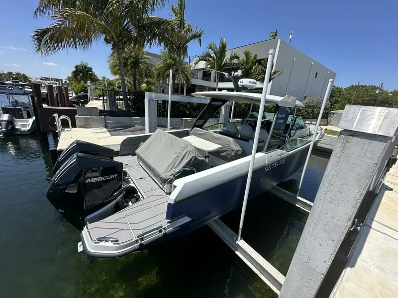 Slide: The Image of 2022 Saxdor 320 GTO boat docked with twin Mercury engines, surrounded by palm trees. - 3