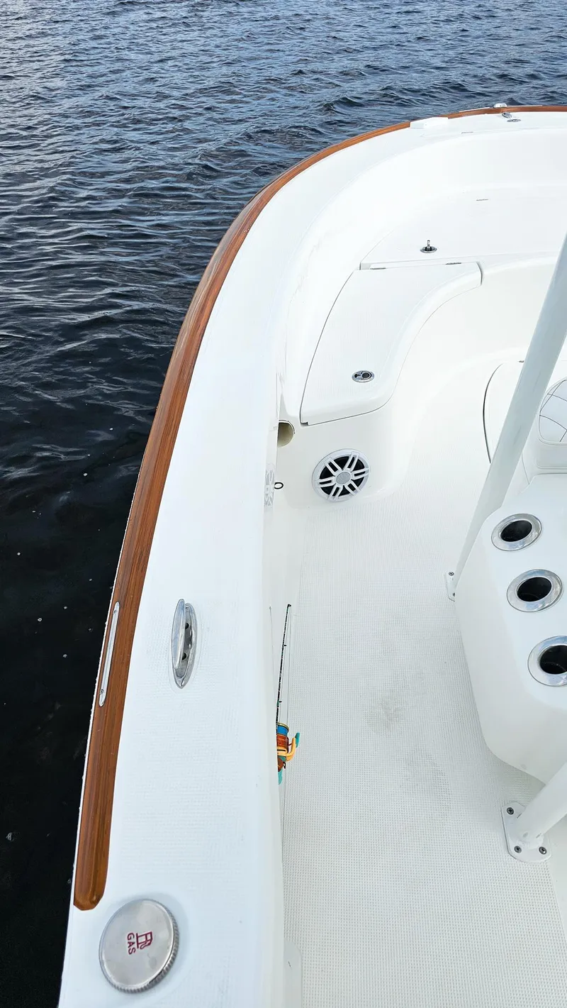 Slide: The Image of 2025 Chaos 21 Tarpon Bay boat deck with wood trim on water. - 14