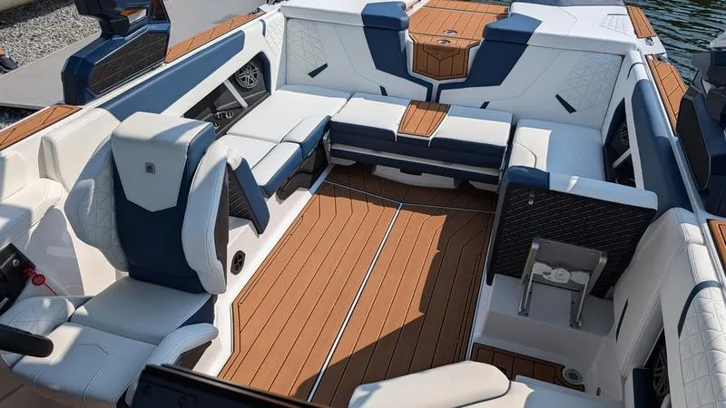 Slide: The Image of 2025 Nautique Super Air Nautique GS22 interior with luxurious seating and teak flooring. - 12