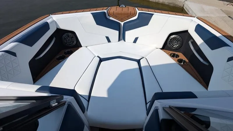 Slide: The Image of 2025 Nautique Super Air Nautique GS22 boat interior with white and blue seating. - 13