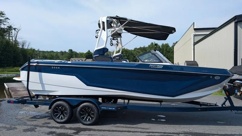 Slide: The Image of 2025 Nautique Super Air Nautique GS22 boat on trailer, blue and white design. - 6