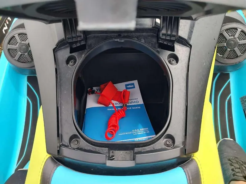 Slide: The Image of Open storage compartment of 2022 Yamaha WaveRunner GP1800R with manual and safety lanyard. - 13