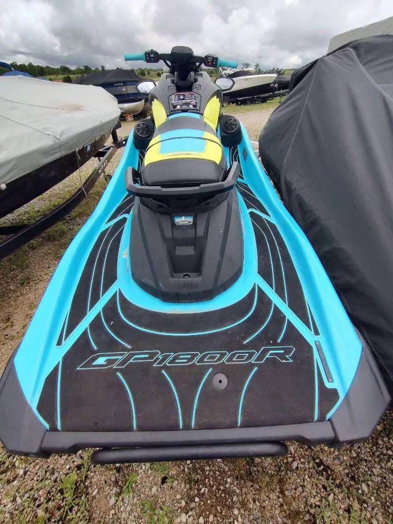 Slide: The Image of 2022 Yamaha WaveRunner GP1800R in vibrant blue and yellow, parked outdoors. - 2