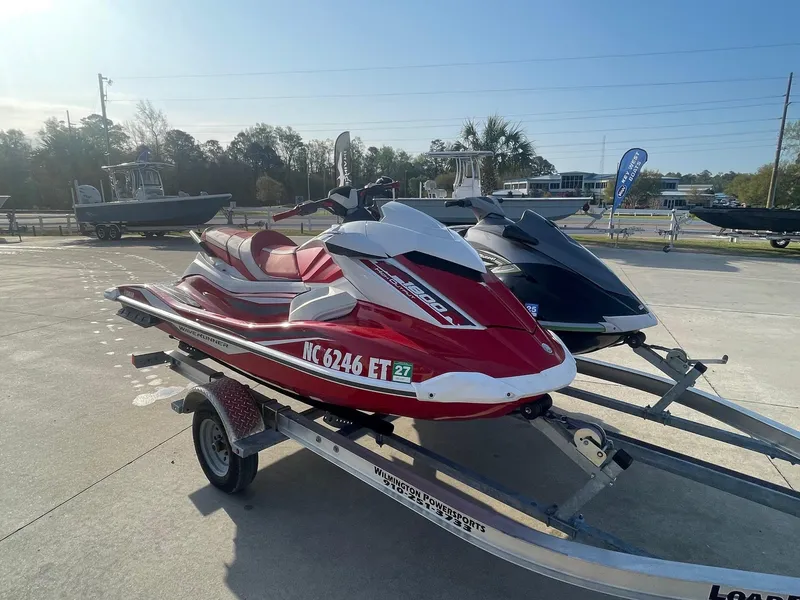Slide: The Image of 2021 Yamaha WaveRunner GP1800R HO in red on a trailer, parked outdoors. - 4